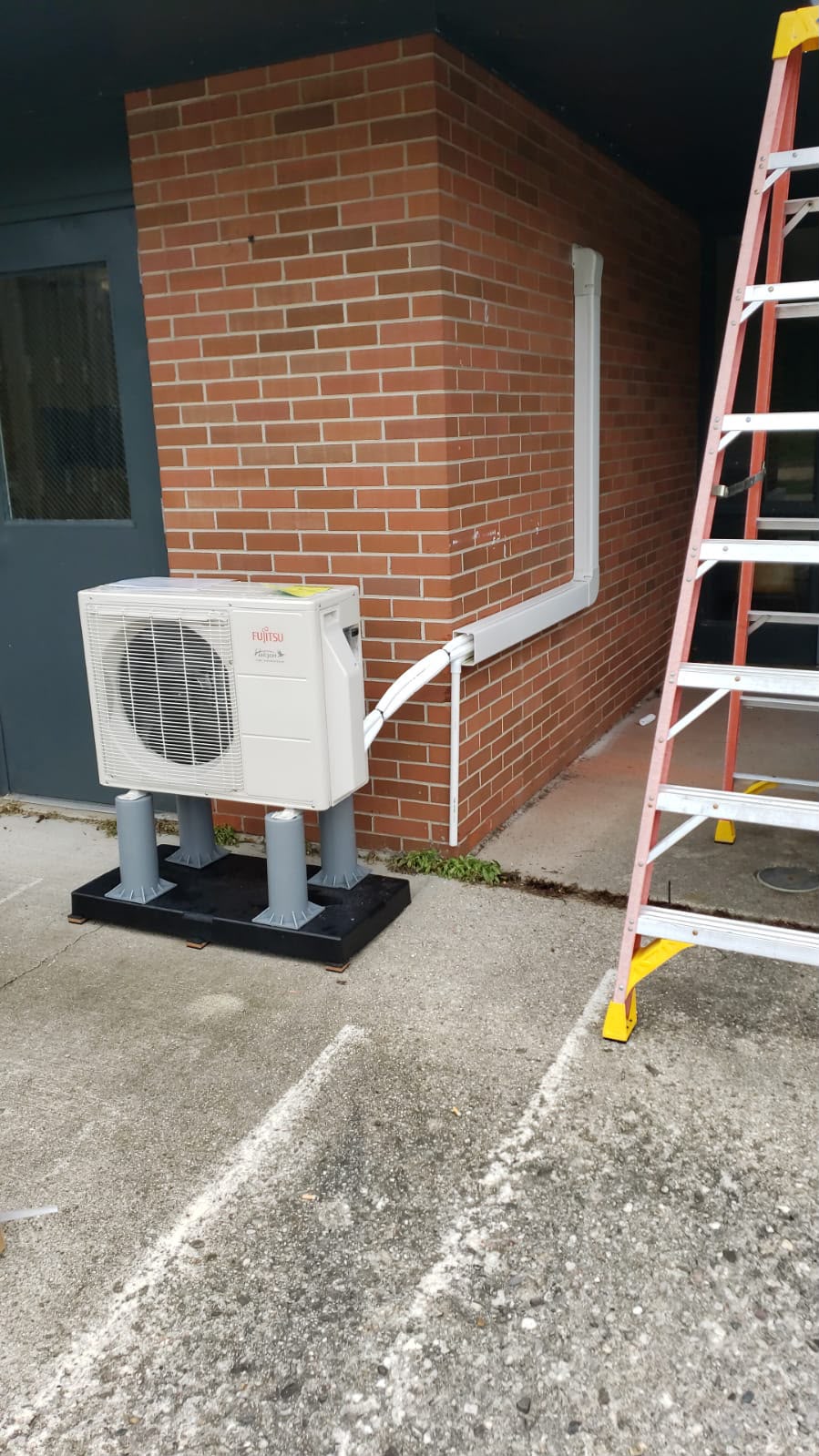 Fujitsu ductless condenser set on pads with line-set covers